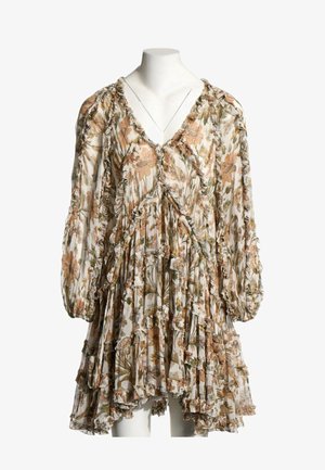 Robe ample à manches longues avec des bords volantés et un motif floral dans des tons de brun, vert et beige sur un fond clair.