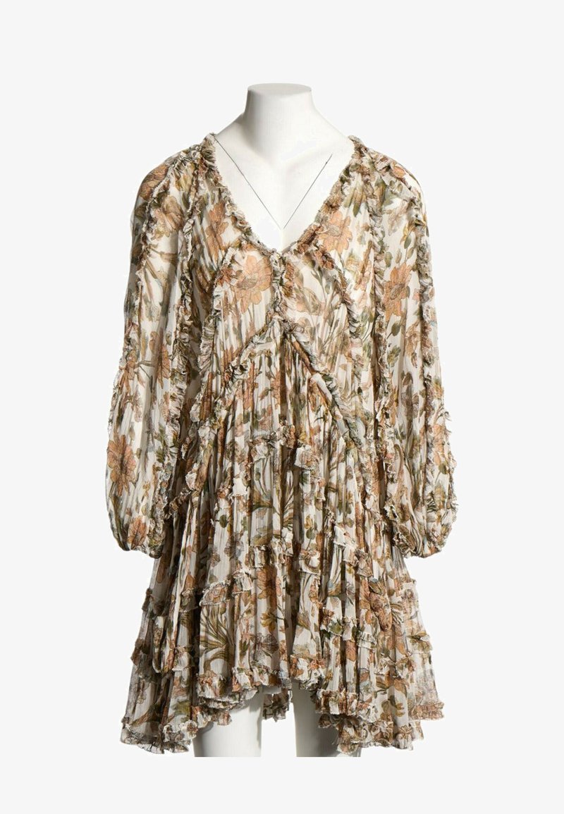 Robe ample à manches longues avec des bords volantés et un motif floral dans des tons de brun, vert et beige sur un fond clair.