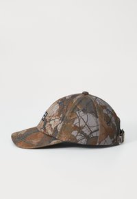 Brun og grå camouflagesnapback med en buet skygge, tekstilstruktur og et lille logo-label på siden, som har et struktureret krone-design.