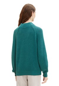 Tropfgrüner, gerippter Pullover mit hohem Kragen und langen Ärmeln, der eine lässige Passform und strukturierte Stoffdetails aufweist.