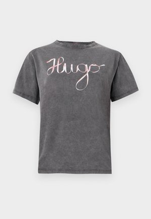 Grey cotton T-shirt with a round neck and short sleeves, featuring a pink cursive "Hugo" logo across the chest. Soft texture and casual design.