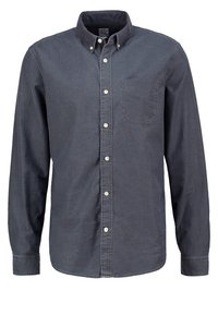 Chemise gris foncé boutonnée en mélange de coton, avec un col classique, des manches longues, une poche poitrine simple et des boutons blancs. Texture douce.