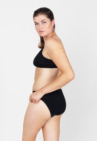 Zwart zwemset bestaande uit een driehoekige bralette-top en hoge taille bottoms. Glad textuur met minimalistische ontwerpelementen.