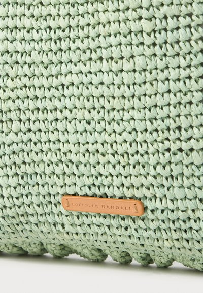 Geantă țesută de culoare verde mentă, cu o suprafață texturată, având un etichetă din piele bej pe care este cusut textul "LOEFFLER RANDALL".
