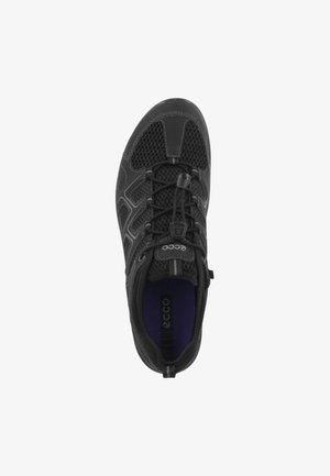 Sort atletisk sko med mesh-paneler, fleksibel sål og elastiske snørebånd. Indvendigt har den lilla polstring. Ecco-logo på tungen.