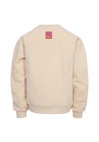 Beige sweater met een ronde halslijn, geribbelde manchetten en zoom. Bevat een kleurrijke vierkante patch op de bovenrug met tekst en een hartontwerp.