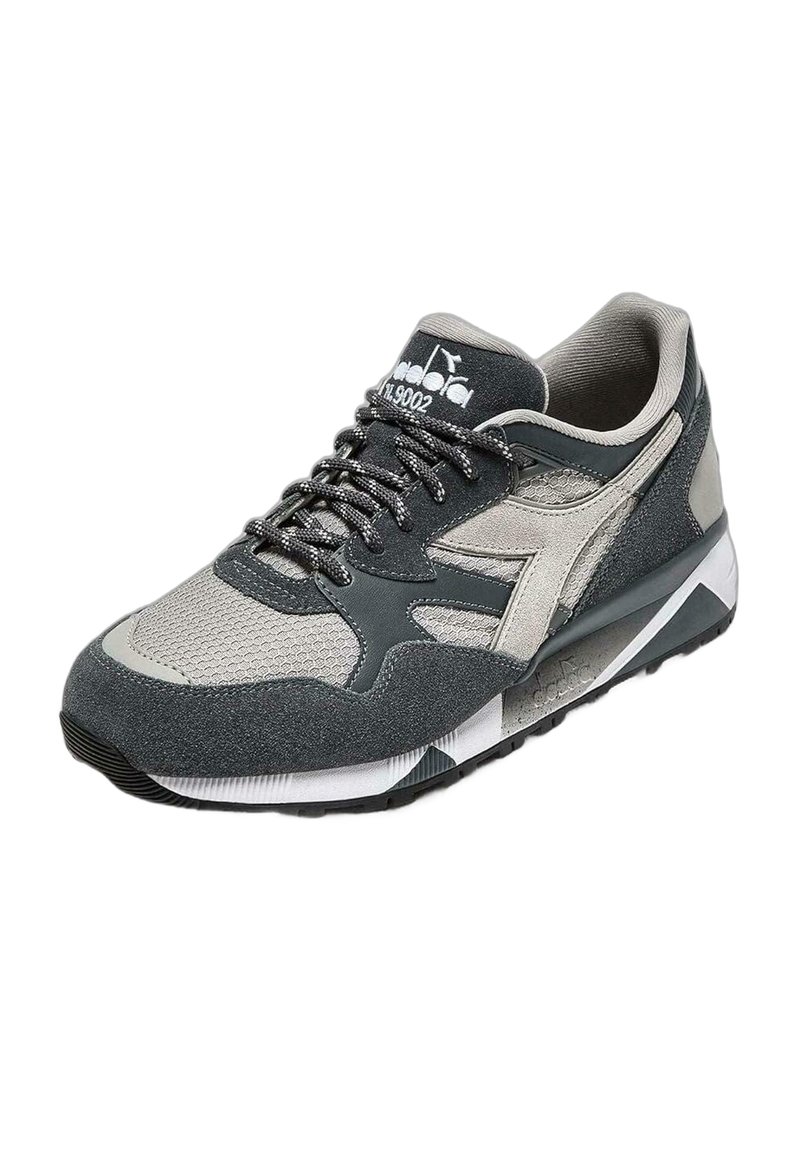 Scarpe sportive con tomaia in mesh grigia e nera, dettagli in camoscio, colletto imbottito, lacci piatti e suola in gomma texturizzata.