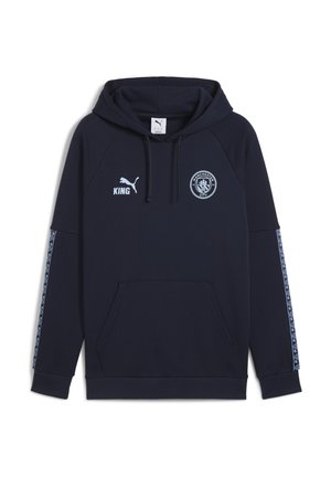Navy hooded sweatshirt with a kangaroo pocket, Puma logo, Manchester City crest, and patterned accents along the sleeves. Cotton blend material.