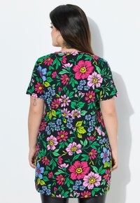 Floral tunic with short sleeves; black background featuring large pink, purple, and blue flowers and green foliage. Soft, lightweight fabric.