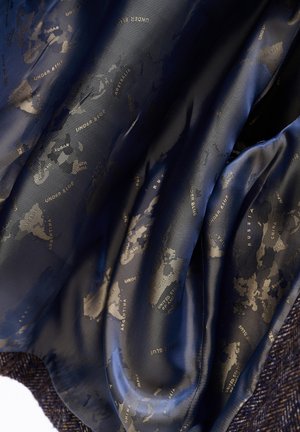 Donkerblauwe zijden stof met een gedrukte wereldkaart waarop landen zijn aangegeven en de herhaalde zin "UNDEER BLUE" in gouden letters.