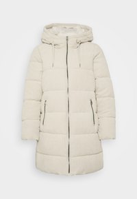 Beige puffjakke med hætte, quiltet design og lynlås foran. Har to sidelommer og en ribbet tekstur hele vejen rundt.