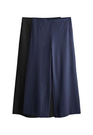 Dos pares de pantalones anchos y cortos, uno en azul marino superpuesto sobre otro en negro, ambos con cintura elástica y tejido suave.