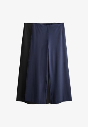 Dos pares de pantalones anchos y cortos, uno en azul marino superpuesto sobre otro en negro, ambos con cintura elástica y tejido suave.