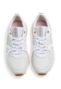 White sneakers with a textured mesh and smooth leather upper, featuring white laces, gold eyelets, and a rubber sole with a patterned grip.