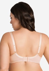 Sujetador beige con tirantes ajustables, cierre de gancho y ojal, y acentos de encaje en los bordes, mostrando una textura de tela suave.