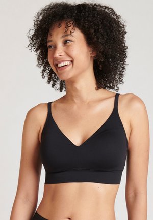 Zwarte bralette gemaakt van gladde stof, met een diepe V-halslijn, dunne verstelbare bandjes en een naadloos ontwerp. Geen zichtbare hardware.