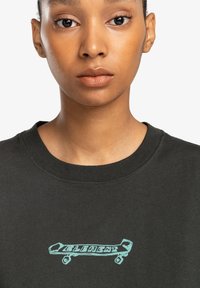 Black cotton t-shirt featuring a turquoise skateboard graphic and the word "ELEMENT" in stylized text across the chest. Crew neck design.