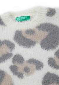 Puszysty biały sweter o miękkiej fakturze z motywem panterki w odcieniach szaro-beżowych. Metka głosi "United Colors of Benetton."
