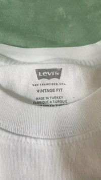 White t-shirt collar with a label reading "Levi's Vintage Fit," indicating it was made in Turkey. Ribbed texture around the neck.
