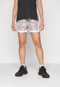 Lightweight shorts with a snakeskin pattern in beige and gray, featuring white side stripes. Paired with black athletic shoes and white socks.