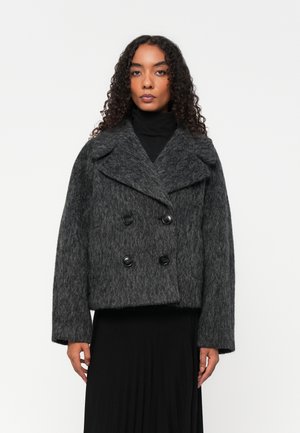 Dobbelspent grå ullblandingsjakke med brede revers, to store svarte knapper og korte ermer. Fuzzy tekstur og avslappet passform.