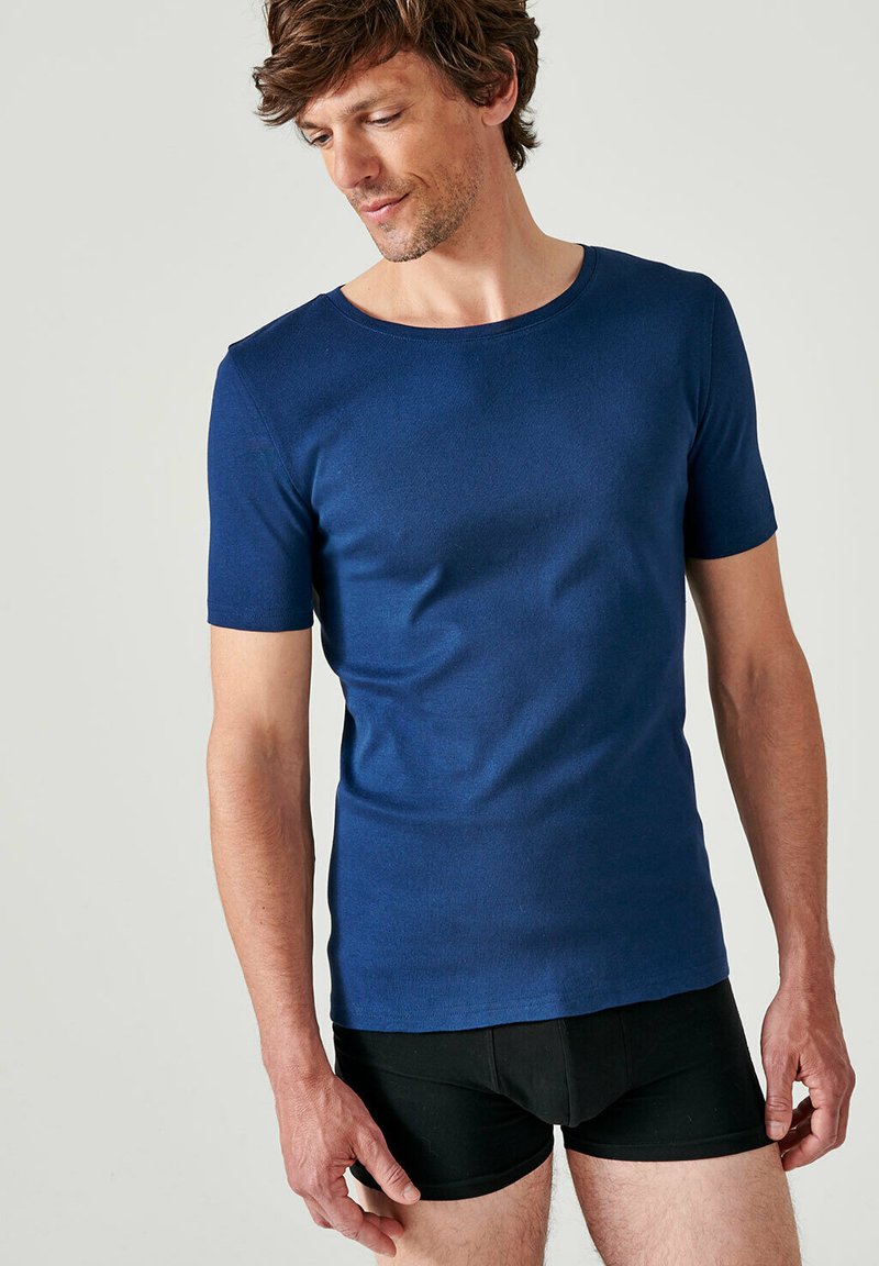 Korte mouwen ronde hals t-shirt in marineblauw, gemaakt van zachte stof, sluit nauw aan op het lichaam, met minimale naden en een strakke vormgeving.