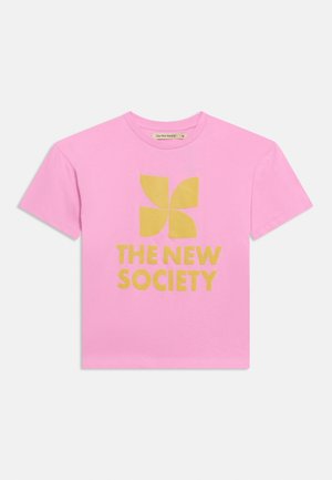 T-shirt rose à manches courtes avec un logo jaune à quatre pétales et le texte "THE NEW SOCIETY" imprimé au centre sur le devant.