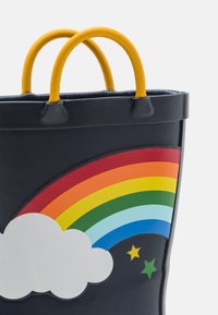 Granatowa gumowa torba na ramię z żółtymi uchwytami, ozdobiona grafiką tęczy, białą chmurą i zielonymi gwiazdkami. Gładka faktura, zaokrąglony kształt, żywe kolory.