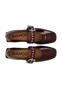 Bordowe lakierowane baleriny z kwadratowym noskiem, z ozdobnym paskiem z srebrnymi ćwiekami i zapięciem na klamrę. Widoczna nazwa marki "BIANCO".