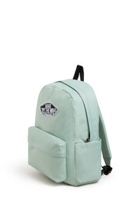 Mintgrön ryggsäck med rundad topp, framficka, svart logotypmärke och justerbara remmar. Tillverkad av hållbart tyg med slät textur.