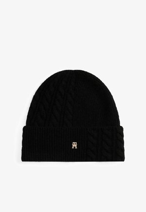 Bonnet en tricot noir avec un motif de tricot à torsades sur le corps et un revers côtelé. Présente un petit accent de logo doré à l'avant.