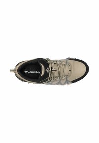 Calzature Columbia in rete beige chiaro con accenti scuri. Presentano un motivo testurizzato, suola nera e un sistema di allacciatura per una vestibilità sicura.