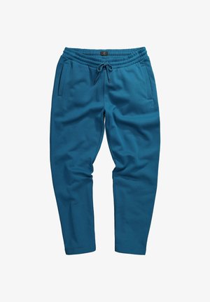 Pantalon de jogging bleu en tissu doux, avec une taille élastique à cordon de serrage, des poches latérales et un petit logo près de la taille.