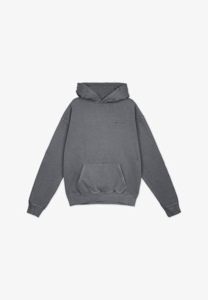 Šedá, oversized mikina s kapucí, která má vpředu klokaní kapsu, šňůrku na stažení a žebrované manžety. Na hrudi se nachází nenápadné logo. Žádné vzory.