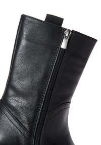 Stivaletto in pelle nera con cerniera laterale, caratterizzato da una texture liscia, dettagli cuciti e una linguetta per una facile calzata.