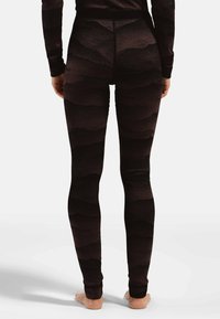 Schwarze Leggings mit einem strukturierten Wellenmuster, einer glatten Oberfläche und einem breiten Bund, die für Komfort und Flexibilität konzipiert sind.