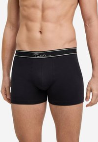 Black boxer shorts made from a soft fabric, featuring a branded elastic waistband with a contrasting line. Simple, streamlined design.