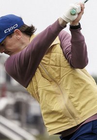 Prešívaná vesta so žltým predným dielom a fialovými rukávmi, so zipsom a stojatým golierom. Nosí sa s modrou čiapkou. Pohyb v golfovom švihu.