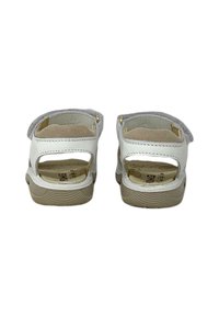 Sandali bianchi con design a intaglio, dettagli in suede e suole in gomma beige. Cinghie in velcro sul retro per una facile indossabilità.