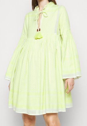 Robe verte clair avec un motif texturé, encolure froncée, manches évasées et lien avec des pompons.