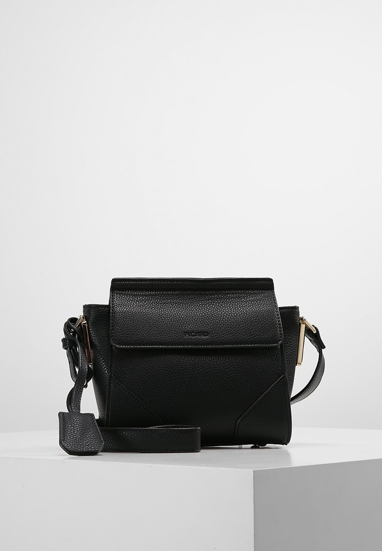 Black leather crossbody bag with a structured shape, top flap closure, textured surface, and gold-tone hardware accents.