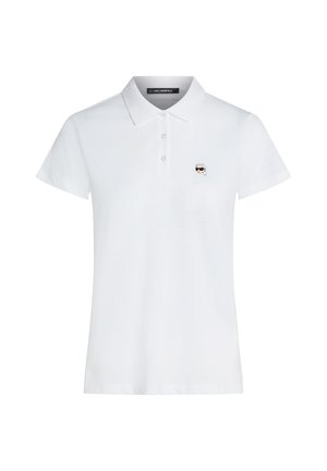 Polo blanc à manches courtes avec col et trois boutons, arborant un petit logo représentant un visage avec des lunettes de soleil sur le côté gauche de la poitrine.