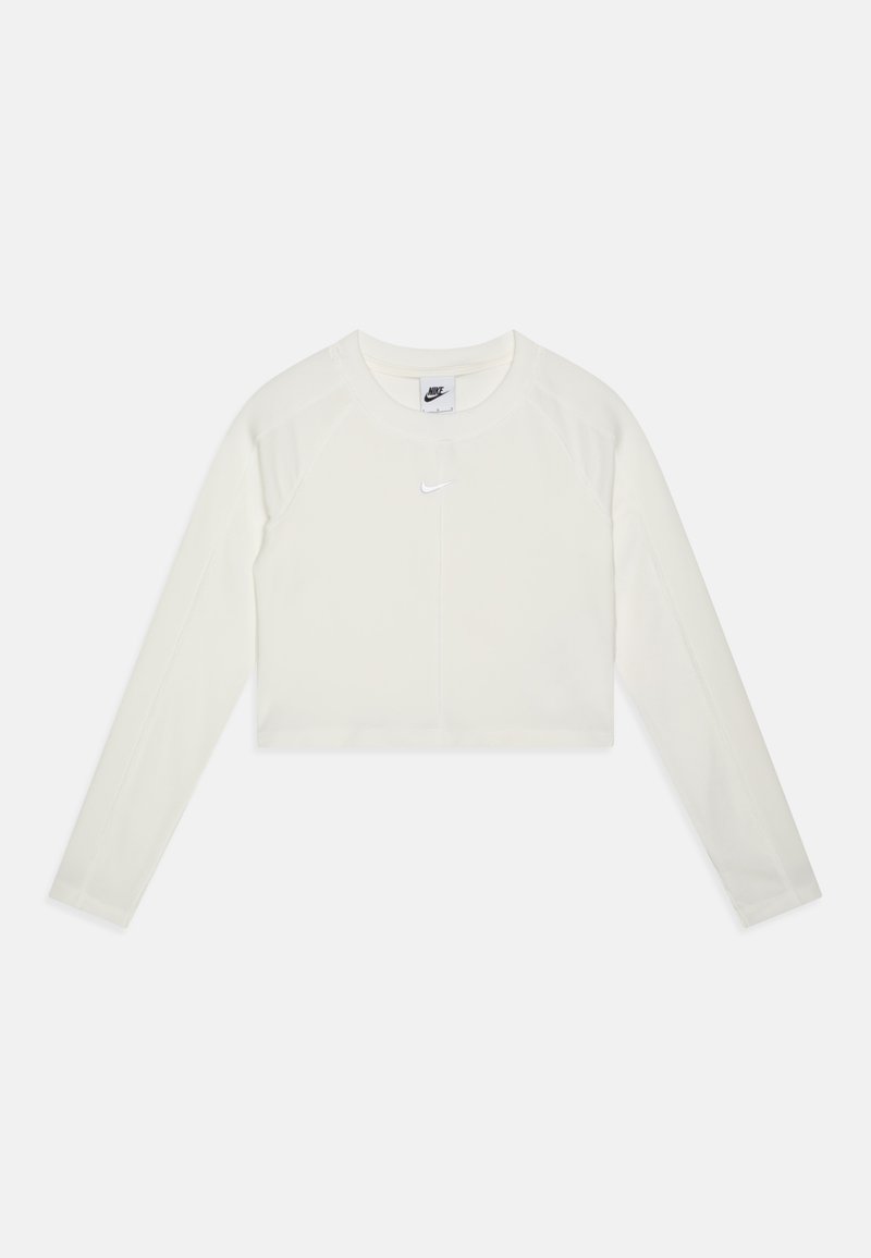 Trumpas ilgomis rankovėmis palaidinė, pagaminta iš kreminės spalvos audinio su glotnia tekstūra. Turi apvalų iškirpimą ir mažą atspindintį Nike logotipą krūtinėje.
