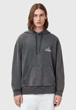 Grijze hoodie met een voorzak, ribgebreide manchetten en een klein wit logo. Zachte stof met een versleten textuur.