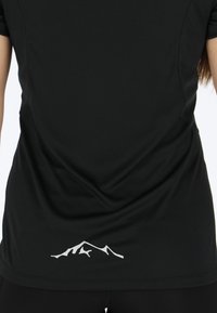 Black athletic shirt with short sleeves, featuring a smooth texture and a white mountain logo near the hem. Seam detailing is visible.