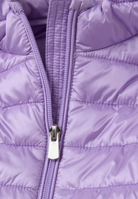Chaqueta tipo puffer de color púrpura claro con textura acolchada, que presenta un zipper plateado y costuras contorneadas para mejorar la forma y el diseño.
