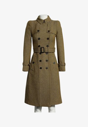 Trench-coat croisé marron à motif chevrons avec boutons noirs et ceinture à la taille, présenté sur un mannequin.