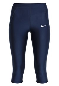 Leggings capri sportivi blu navy con una texture liscia, caratterizzati da un logo Nike bianco sul lato sinistro e cuciture piane.