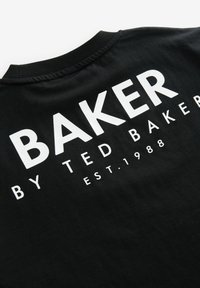 Czarny bawełniany T-shirt z dużym białym napisem z tyłu: "BAKER BY TED BAKER EST. 1988." Miękka tekstura z klasycznym okrągłym dekoltem.