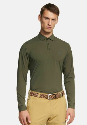 Olijfgroene polo met lange mouwen van stof, voorzien van een knoopsluiting en versierd met een klein logo op de borst, gecombineerd met tan shorts en een gebandeerde riem.